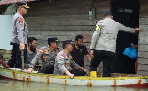 Kapolres Bintan Antar Bantuan dengan Menggunakan Sampan ke Rumah Warga Terendam Banjir