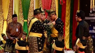 Gubernur Kepri Memasangkan Pingat Saat Kasal Dianugerahi Gelar Adat oleh LAM Riau